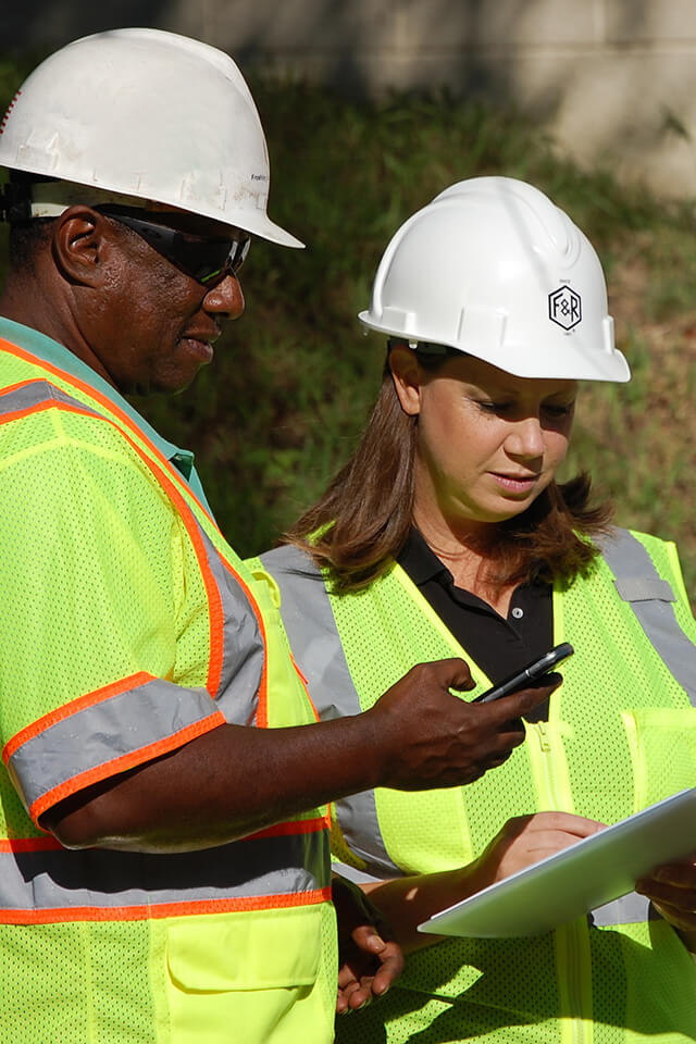 Two F&R employees collaborate in the field